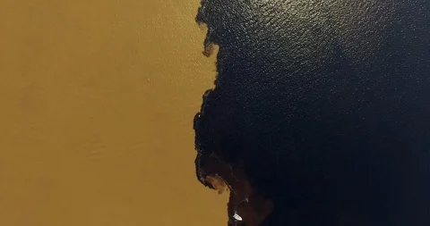Meeting of waters. Еwo contrastingly colored rivers merge spectacularly into Video stock 121781830