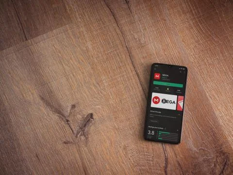 MEGA app play store page on the display of a black mobile smartphone on woode Stock Photos