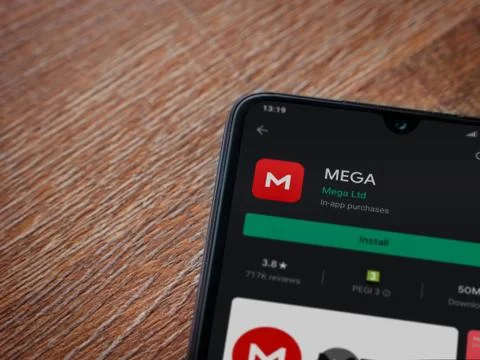 MEGA app play store page on the display of a black mobile smartphone on woode Stock Photos