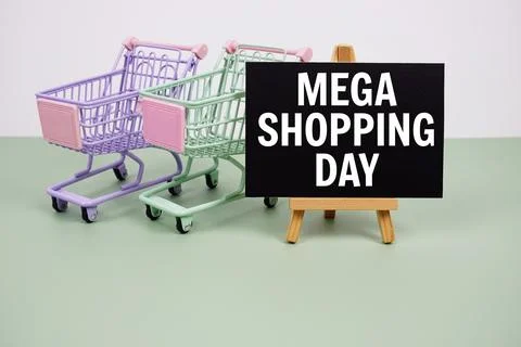 Mega Shopping Day text message and trolley shopping cart on green background Stock Photos