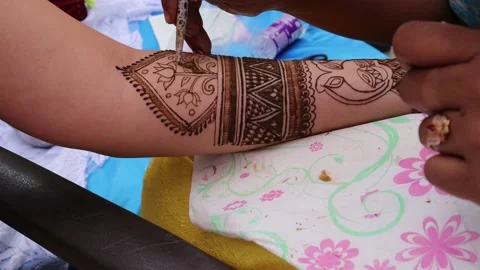 Mehndi artist making beautiful mehndi design on bridal hand. Stock Footage