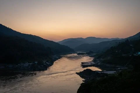 Mekong River at sunset between mountains in Laos Foto stock