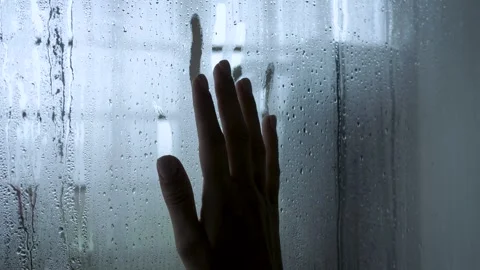 Melancholic hand sliding down a rainy window Stock Footage 332367586
