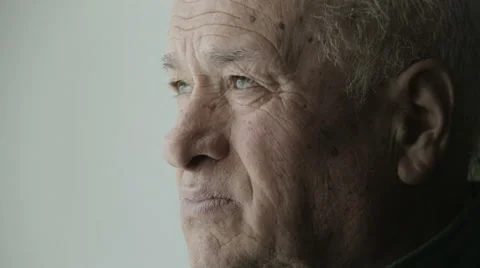 Melancholy old man looking out of the window and drinking coffee or tea  Video stock 48058596