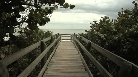 Melbourne Florida Beach boardwalk framed by foliage Atlantic Ocean background Stock Footage 10830908
