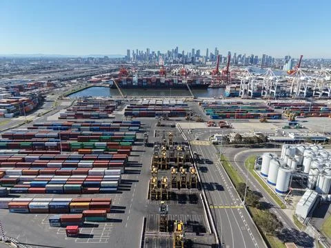 Melbourne port terminal processing cargo containers with city skyline Stock Photos