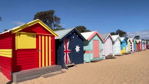 Melbourne: Row of colorfully painted iconic Brighton Bathing Boxes on beach, 4K Stock Footage 297866602