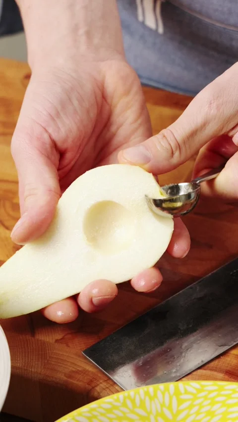 Melon baller removes core and seeds from pear half. Video stock 344769749