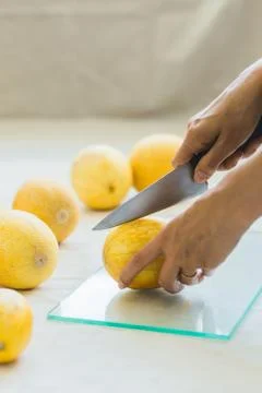 Melon berries on the kitchen table, hands cut melon into halves . Stock Photos