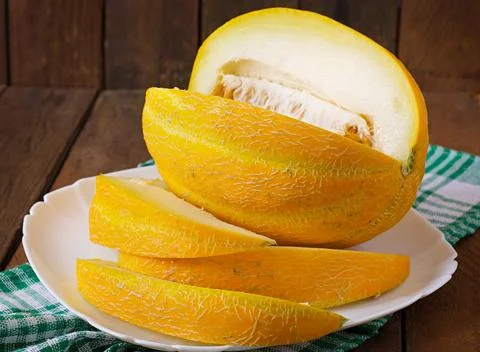 Melon cut into pieces on a plate Stock Photos