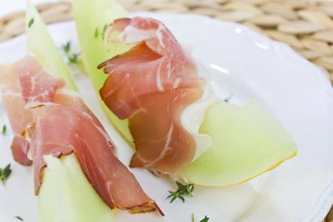 Melon with ham on a plate Stock Photos