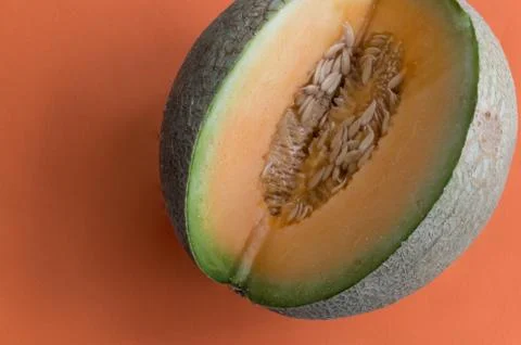 Melon on orange background Stock Photos