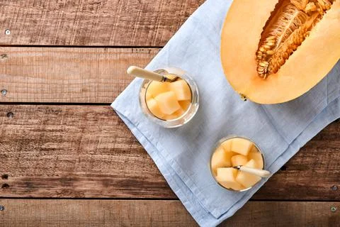 Melon. Pieces of fresh melon for making fruit dessert in glass on an old wood Stock Photos
