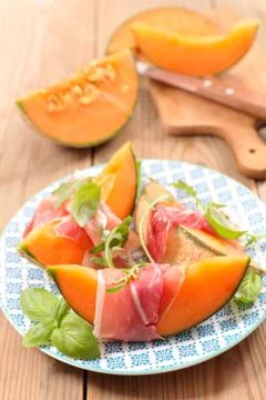 Melon slice with prosciutto Stock Photos