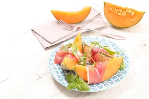 Melon slice with prosciutto Stock Photos
