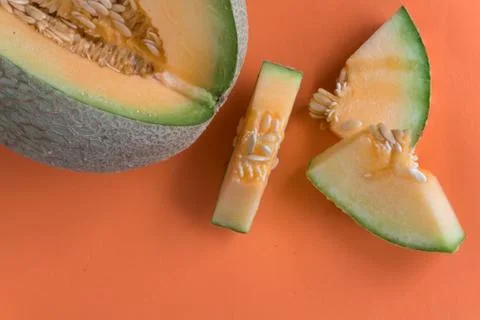 Melon slices on orange background Foto stock