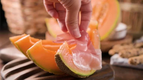 Melon slices with prosciutto ham on board Stockbeeldmateriaal 202278030