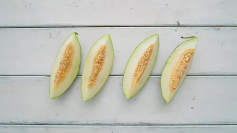 Melon Slices Stop Motion Animation Appearing on White Wooden Background Vídeos de archivo 331101436