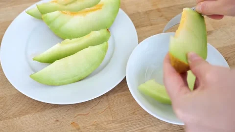Melon slices.piece of ripe melon.Hands cutting slices of melon with a knife Stock Footage 249268571