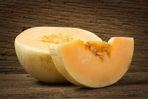 Melon (sunlady) slice. half. on old wood. morning Stock Photos