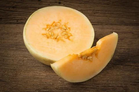Melon (sunlady) slice. half. on old wood. morning Stock Photos
