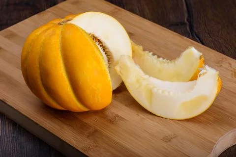 Melon with two cut slices on cutting board Stock Photos