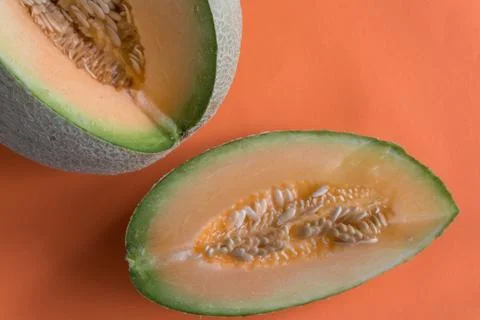 Melon wedge on orange background Stock Photos