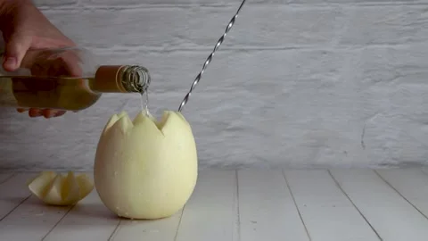 Melon with wine, melvin, preparing, cocktail, adding, white wine. On white wo Stock Footage 258414656