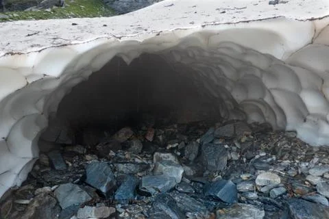 Melt hole under snow patch Stock Photos