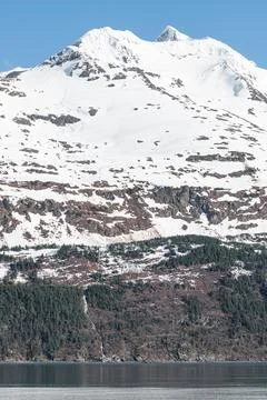 Melt water running down the side of a snow covered mountain, Whittier, Alaska Stock Photos