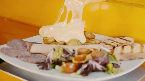 Melted cheese falling over salad with potatoes, ham and bread Stock Footage
