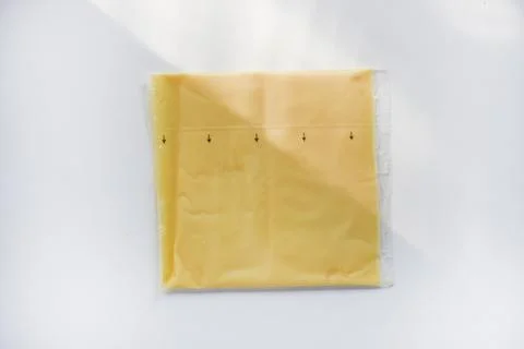 Melted cheese in flat slices. Processed cream cheese for sandwiches. Stock Photos