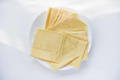 Melted cheese in flat slices. Processed cream cheese for sandwiches. Stock Photos