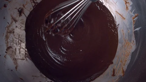 Melted chocolate flowing from a whisk Stock Footage 123311341