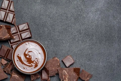 Melted chocolate or Hazelnut spread in glass bowl and chocolate pieces on dark Foto stock