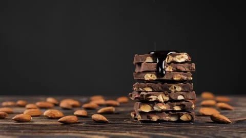 Melted chocolate is poured on a stack of chocolate at the table, Stock Footage 239628405