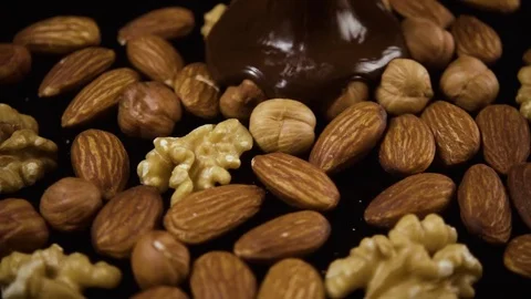 Melted chocolate pours on nuts. Slow motion Stock Footage 74733157