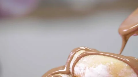Melted chocolate spooned onto donut Stock Footage 166863271