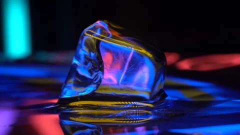 Melted Cube of ice in yellow neon lighting 4K Stock Footage 106830387