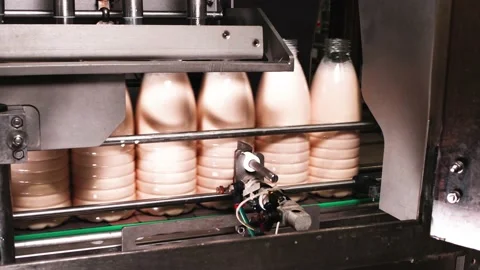 Melted milk is poured into empty plastic bottles on the conveyor Stock Footage 170667808