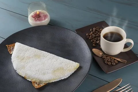 Melted mozzarella cheese tapioca, next to a cup of black coffee blue wood b.. Stock Photos