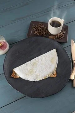 Melted mozzarella cheese tapioca, next to a cup of black coffee blue wood b.. Stock Photos