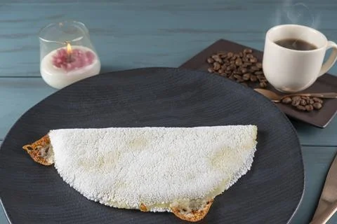 Melted mozzarella cheese tapioca, next to a cup of black coffee blue wood b.. Stock Photos