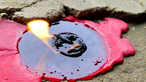 Melted red candle with smoldering flame on cement surface Vídeos de archivo 304718424