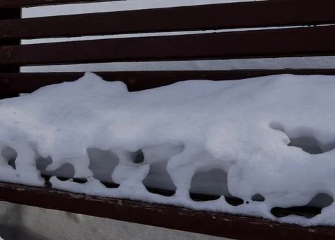 Melted snow on a bench on the eve of spring in East Kazakhstan Foto stock
