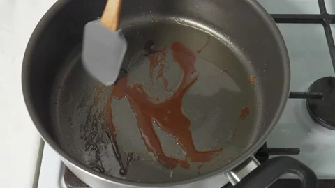 Melted sugar boils in a frying pan on a hot stove, preparing hot caramel. Stir Stock Footage 232407856