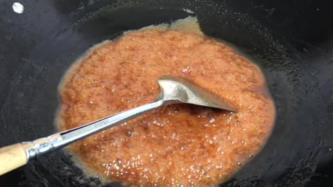 Melted sugar boils in a pan over medium heat stove Stock Footage 244637528