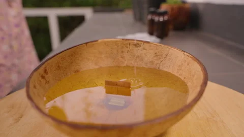 Melted Wax Dripping in Thin Stream into Large Rustic Coconut Shell Candle Bowl Stock Footage 316841949