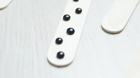 Melting black hard wax beans on a wooden spatula, preparing for a depilation Stock Footage 311975267
