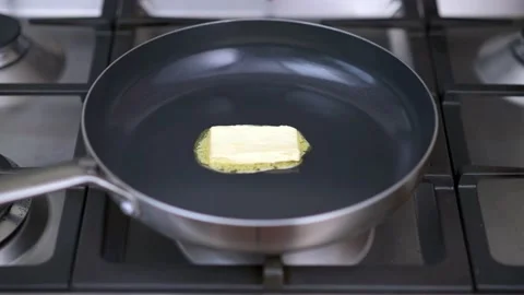 Melting butter in a pan Stock Footage 147993677